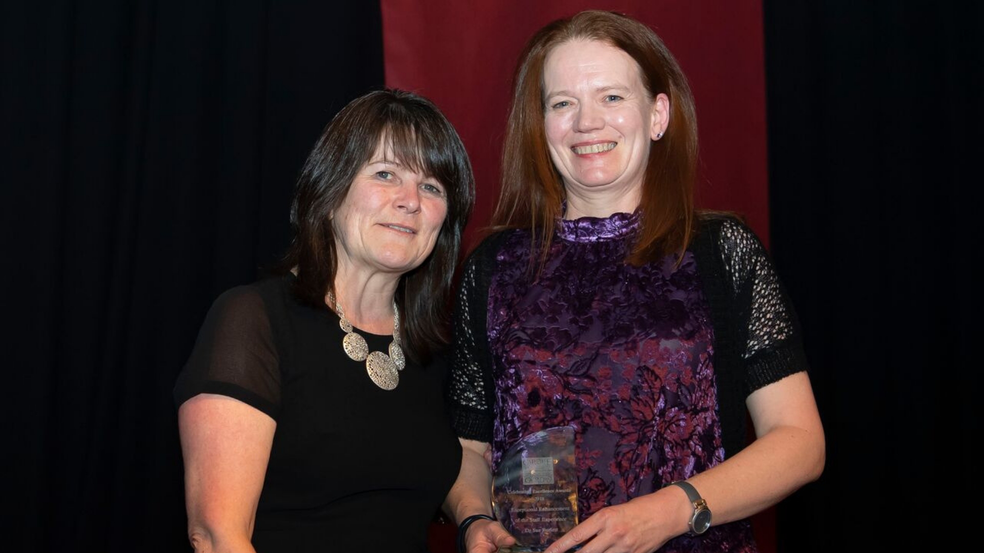 Two women holding award