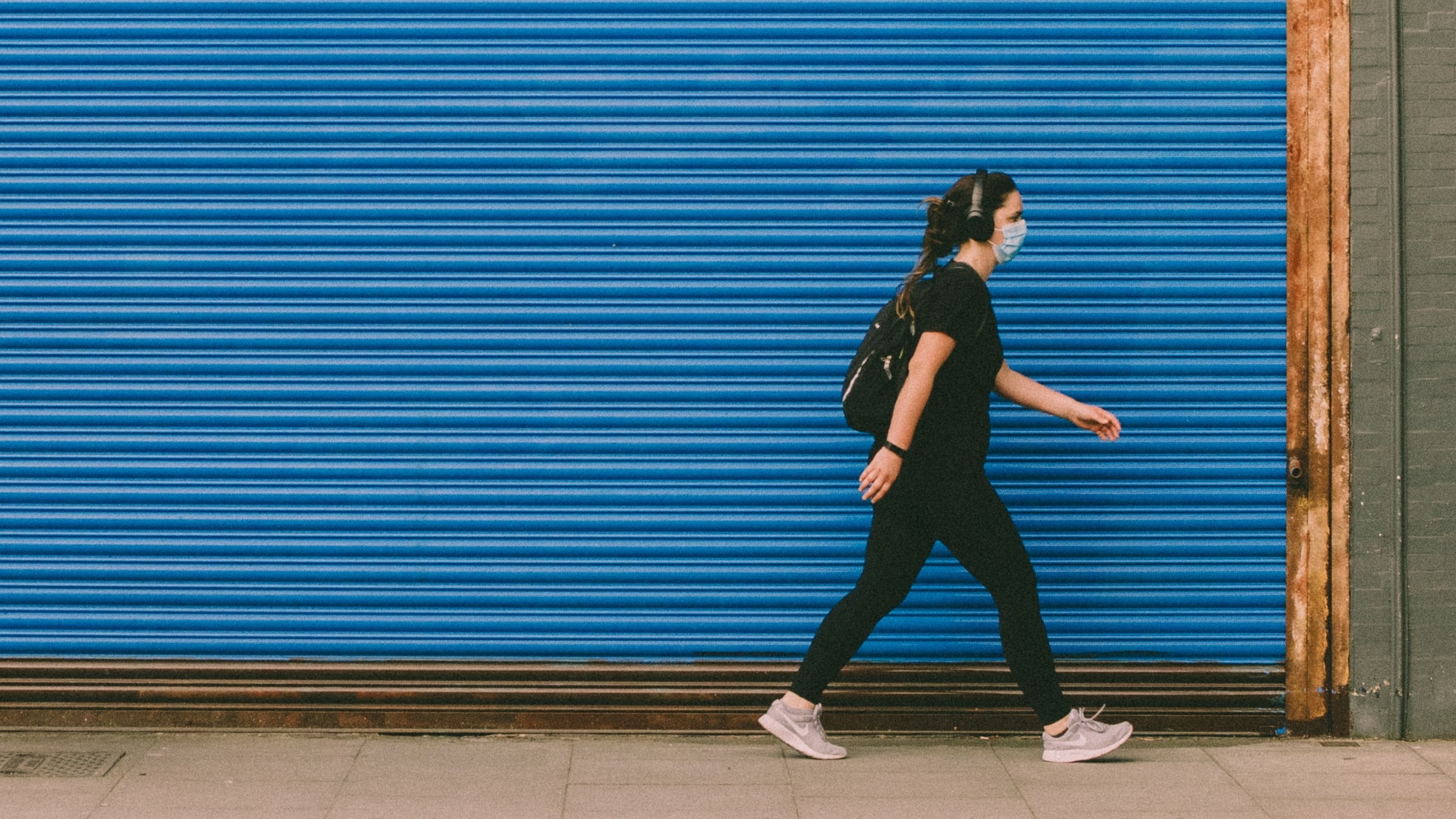 woman walking wearing mask
