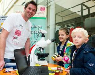James Blaxland showing children the pollen in honey through a microscope during Environmental Day