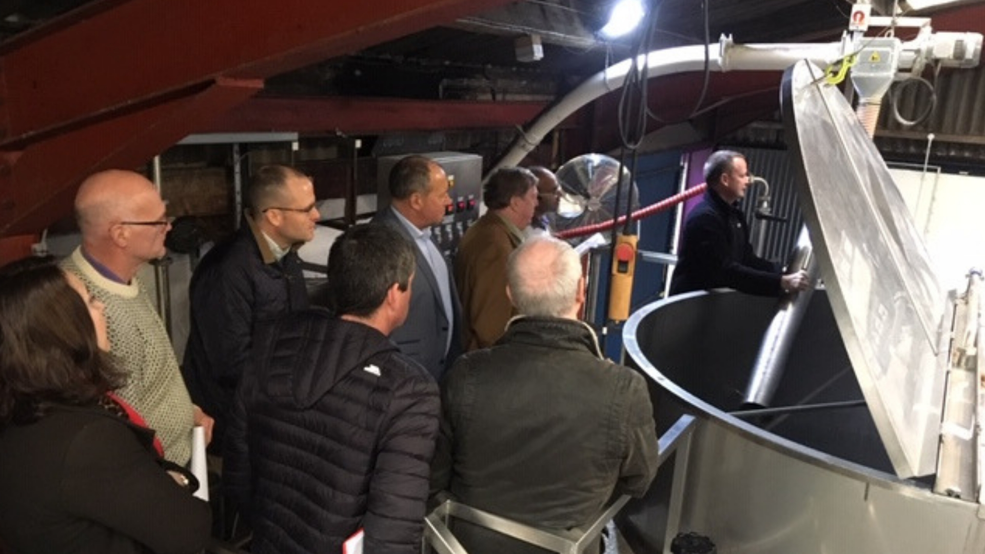 people gathered around brewing equipment