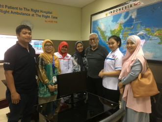 group of 7 Indonesian people, men and women stood in front of a map of Indonesia.