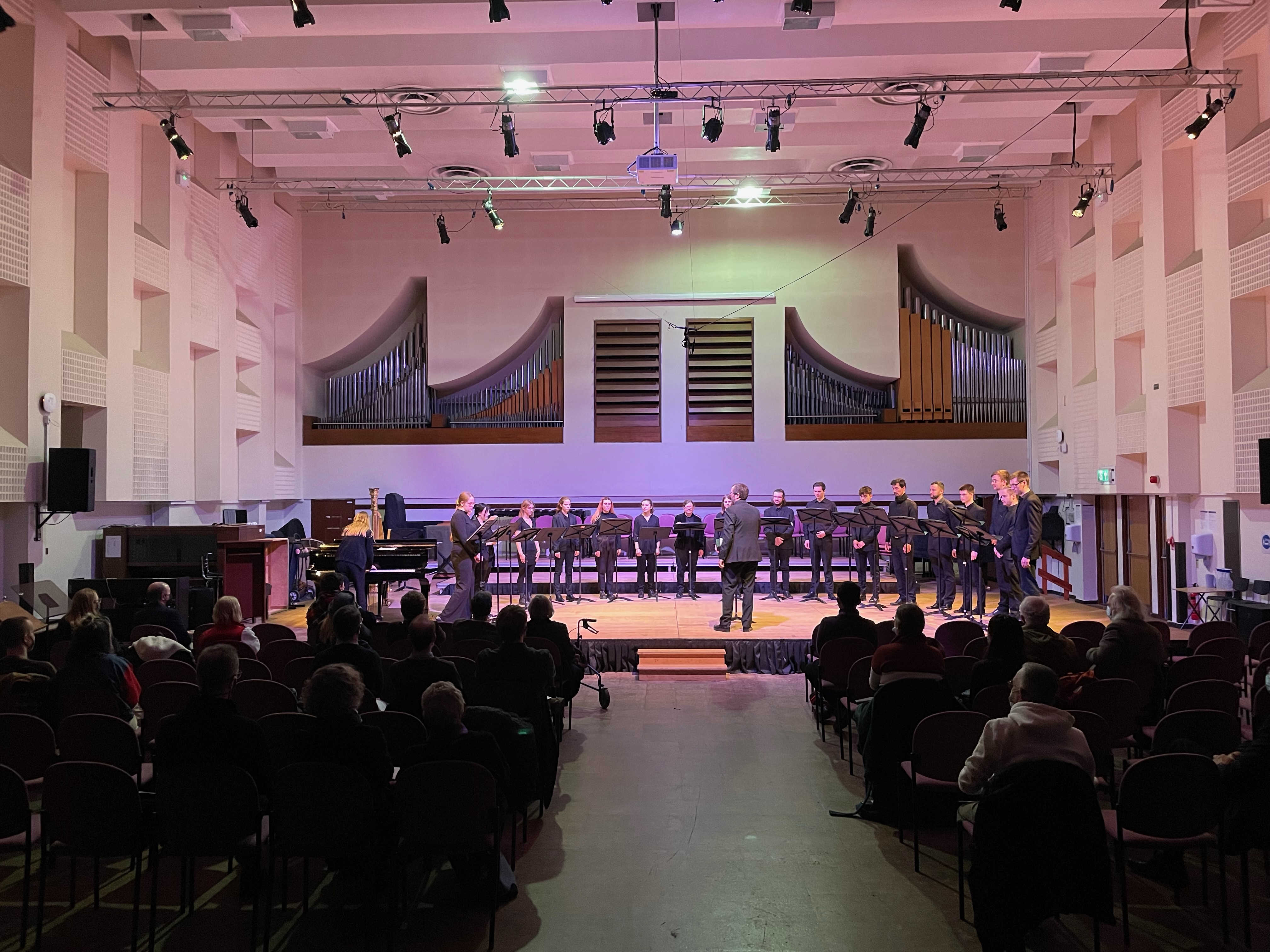 Students and a composer on stage performing.