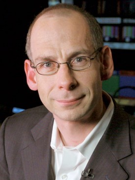 Image of  a man wearing glasses and a suit