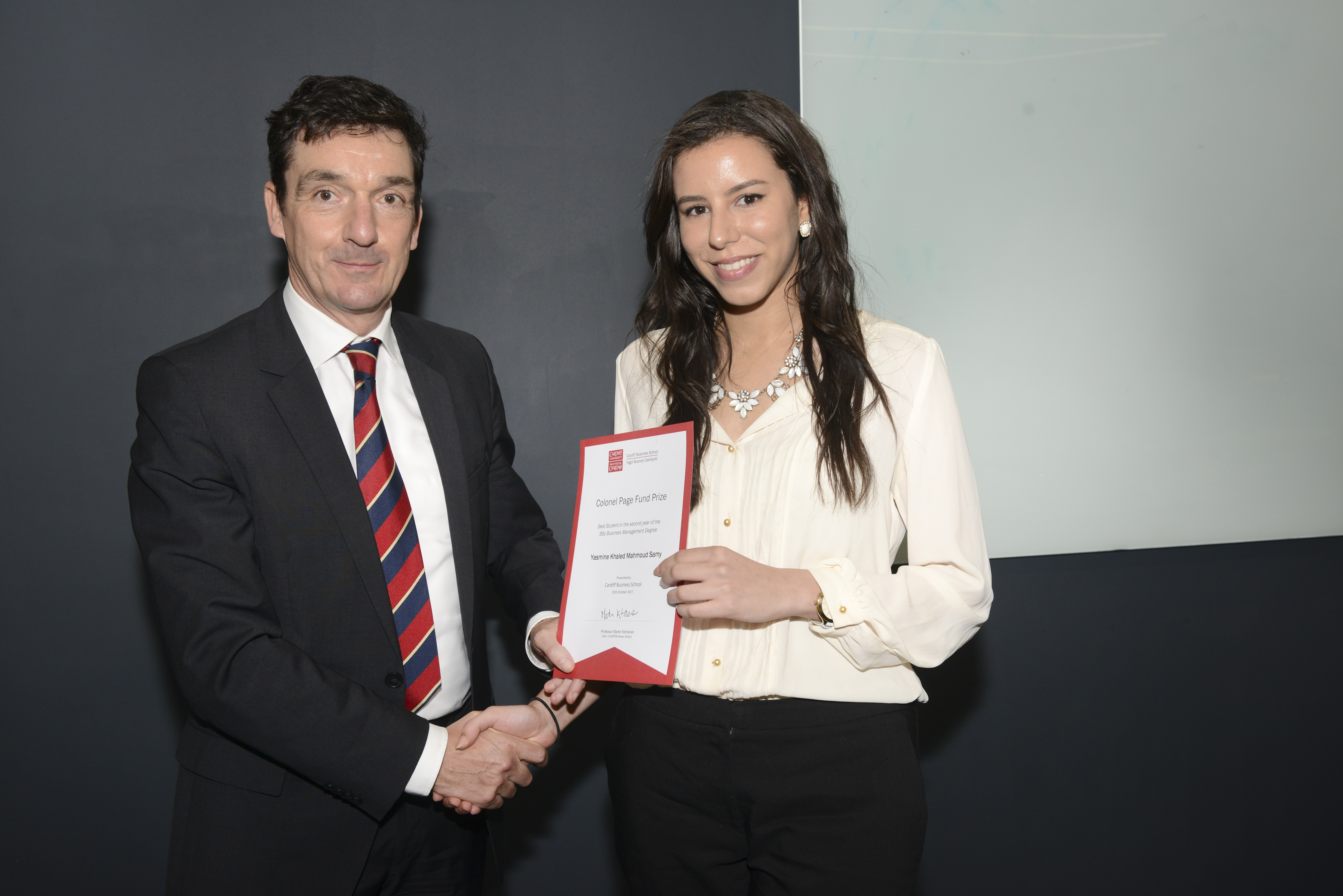 Woman receiving certificate from man