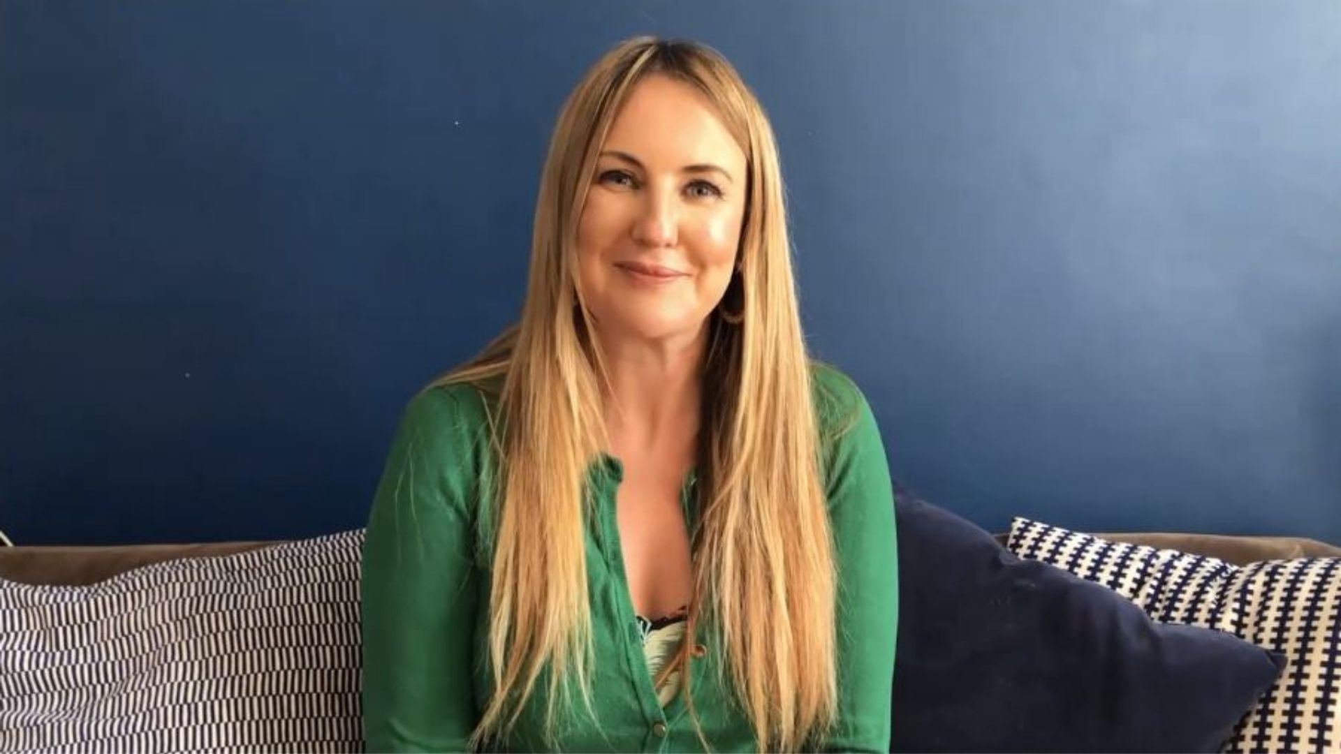Woman speaks to camera from home