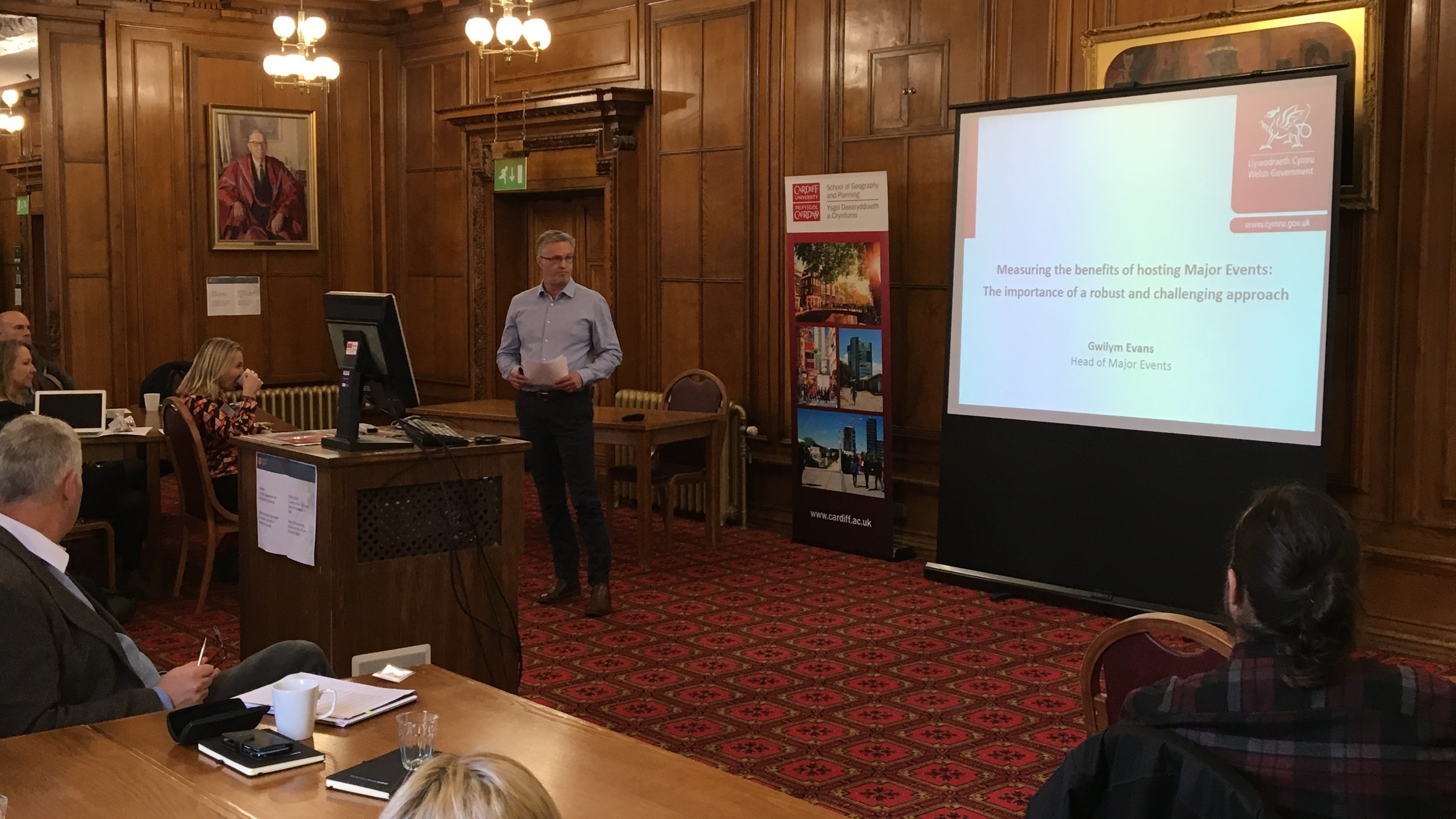 Image of male presenting in front of powerpoint screen