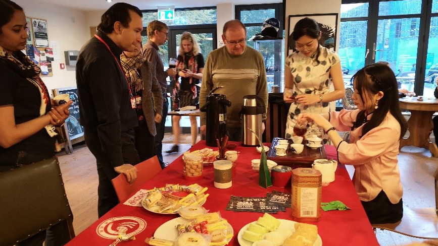Lin He, CCI tutor, serves tea to international staff