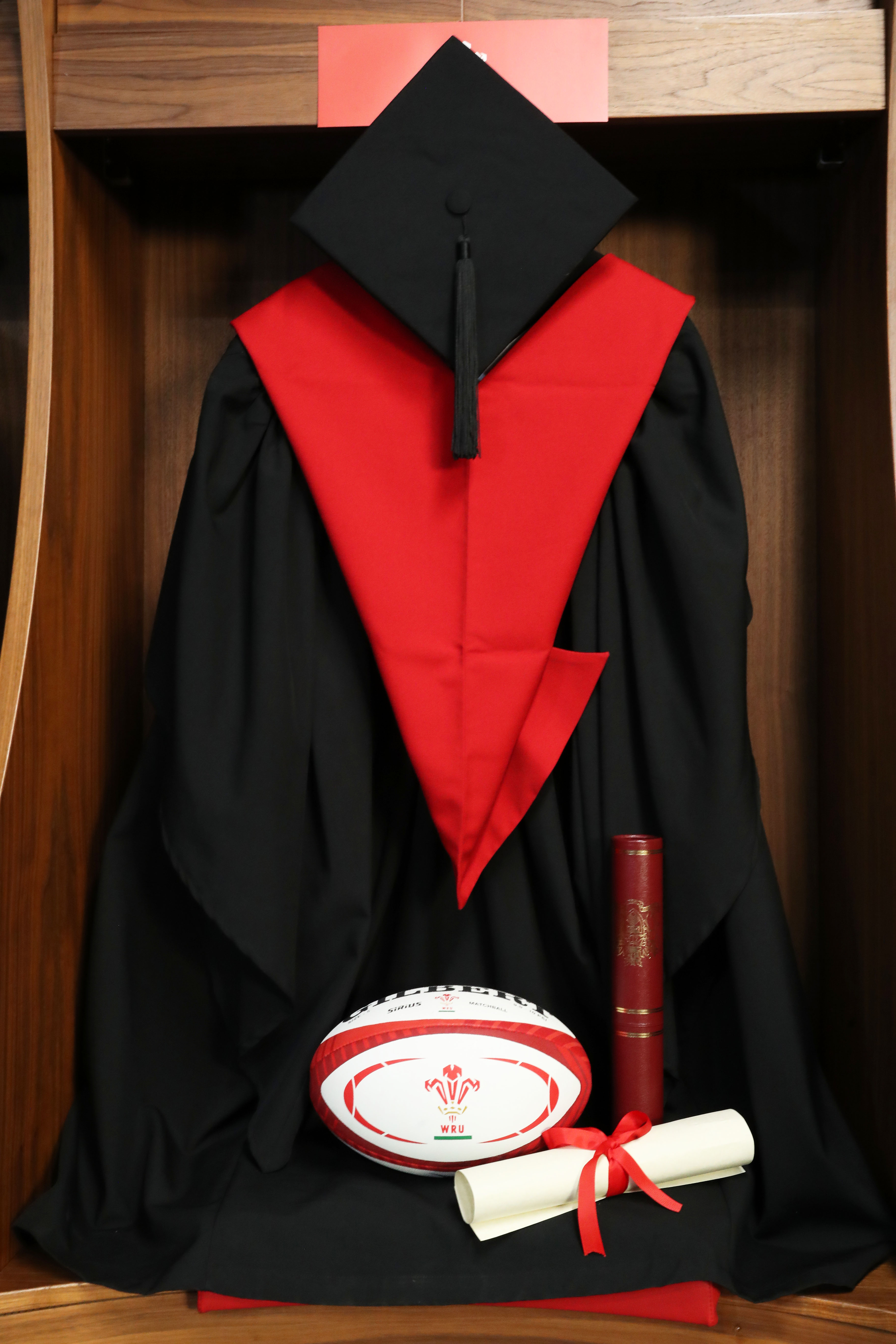Graduation gown, rugby ball and scroll in Principality changing rooms