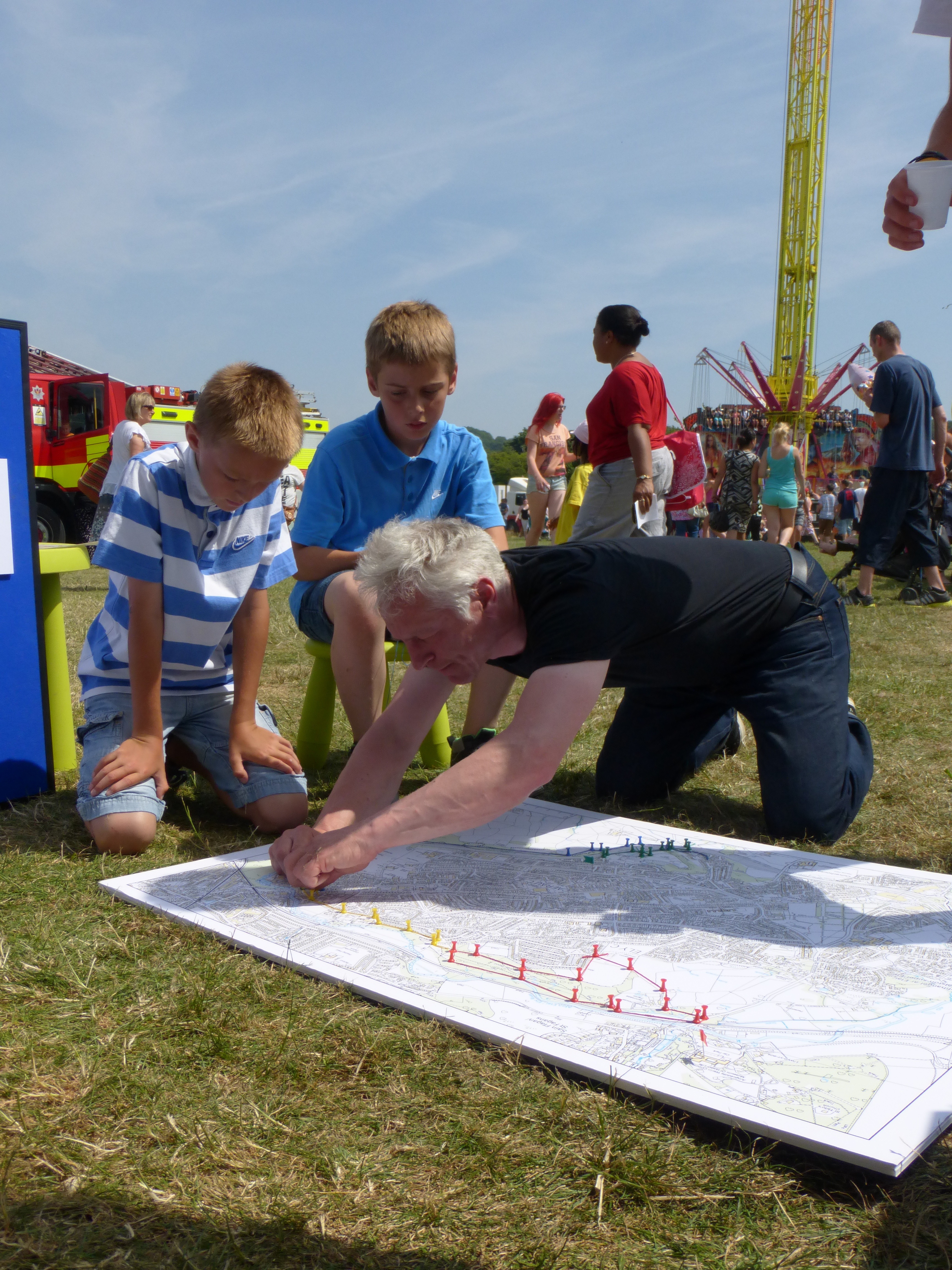 Man and two children dropping pins on map