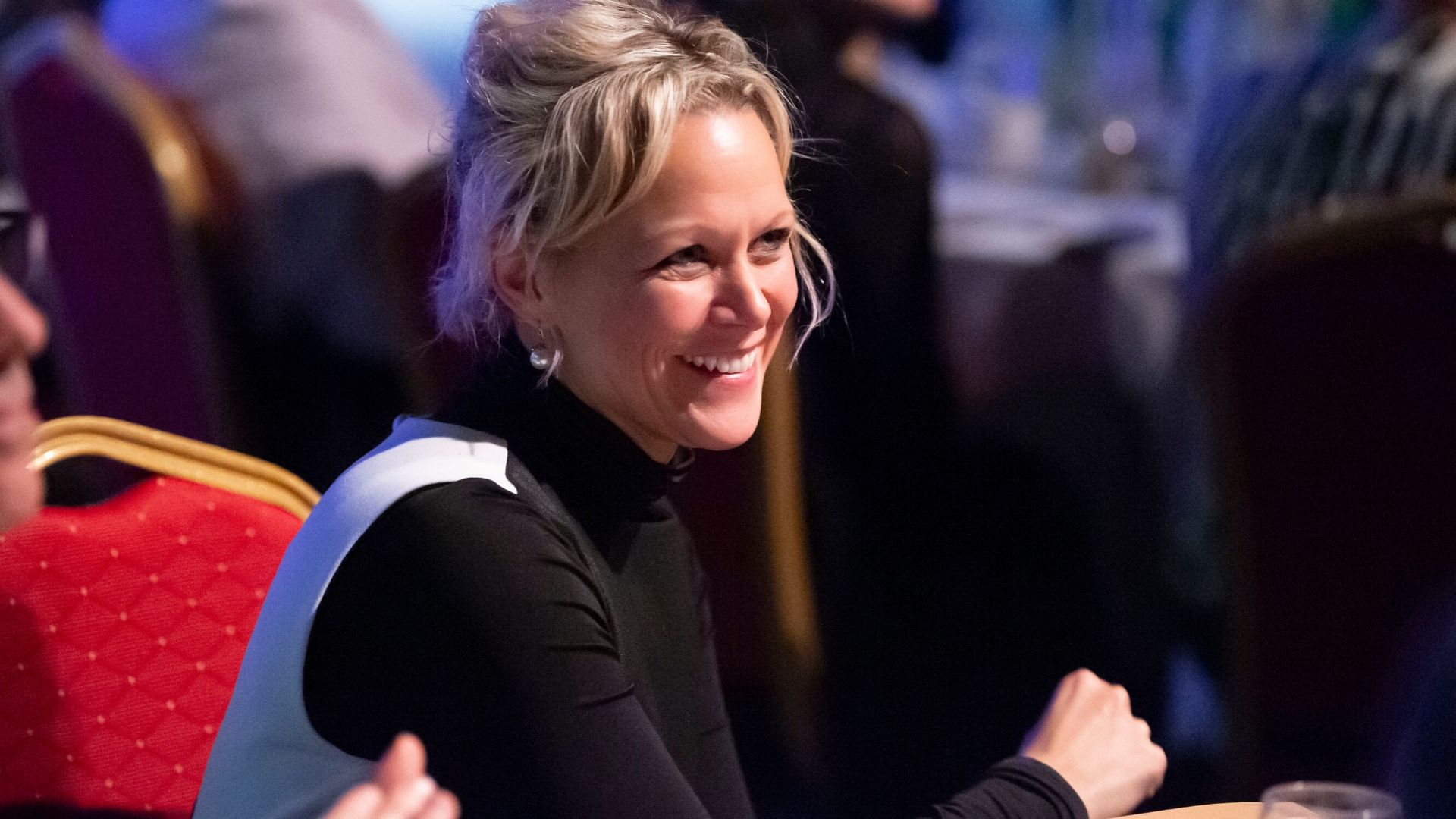 Woman laughing at awards ceremony