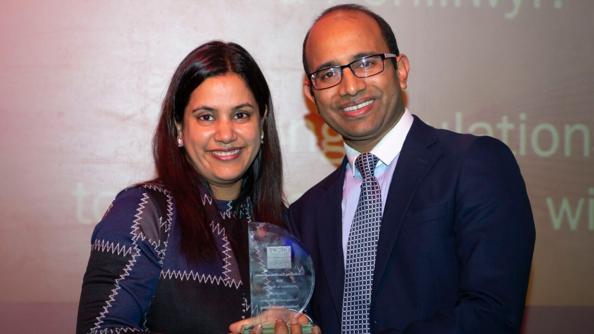 Man and woman hold award