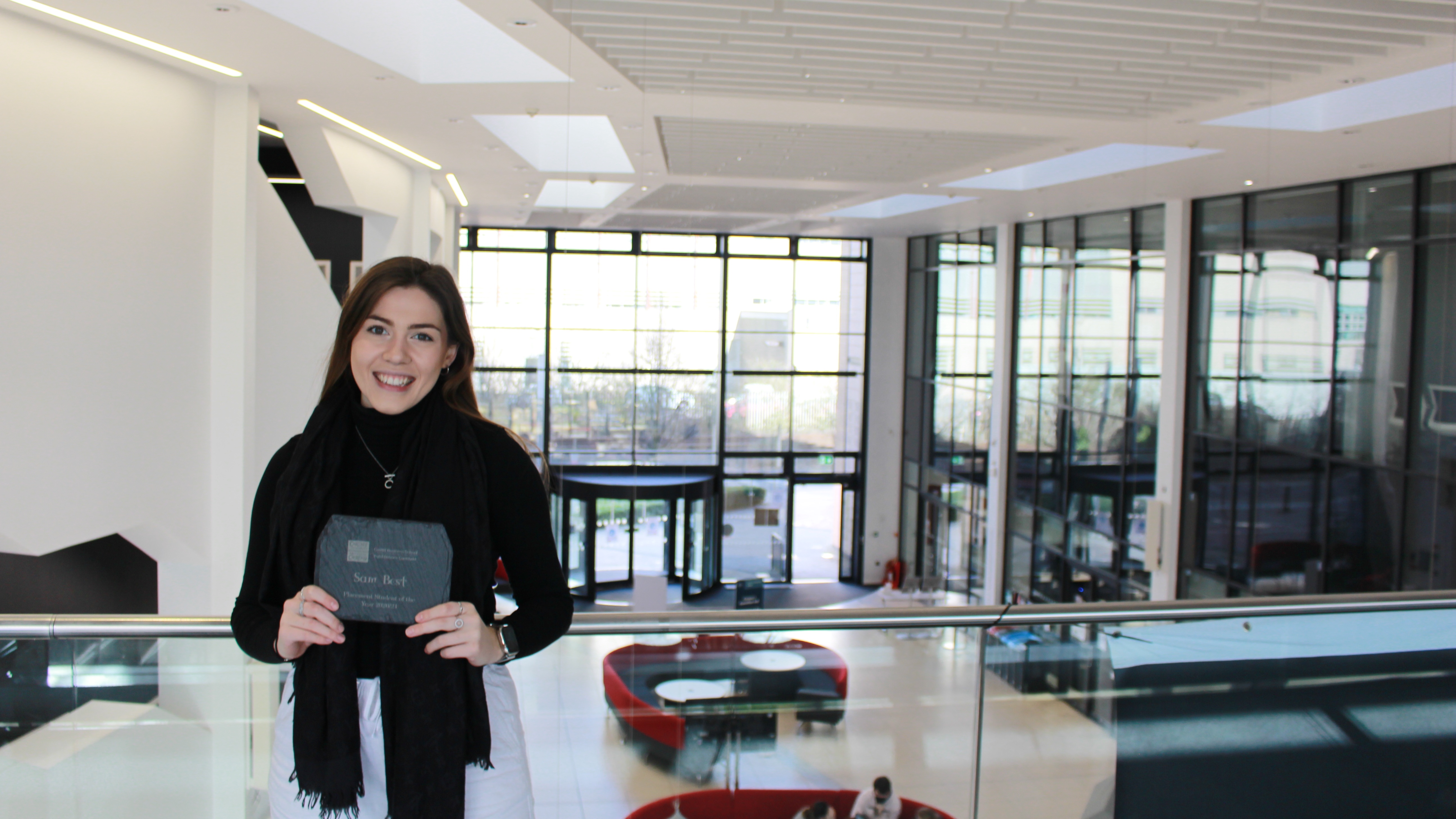 Samantha Best in the Postgraduate Teaching Centre holding an award for Intern of the Year